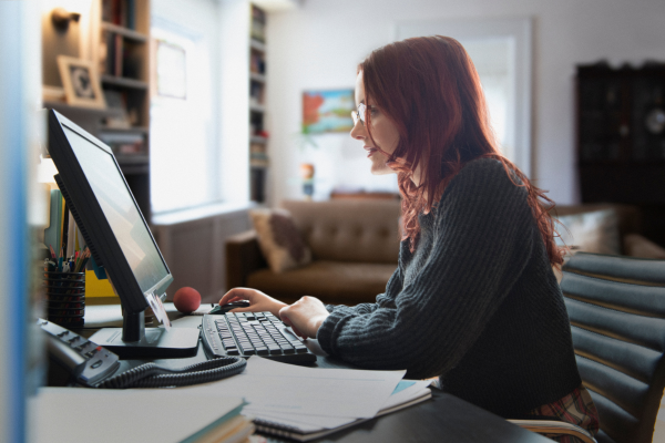 Pessoa focada trabalhando em casa para conquistar renda extra com organização e mentalidade positiva.